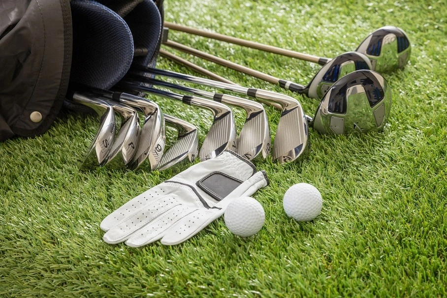 Multiple golf clubs and a golf bag lying on the grass. Complete Golf Sets for Rent