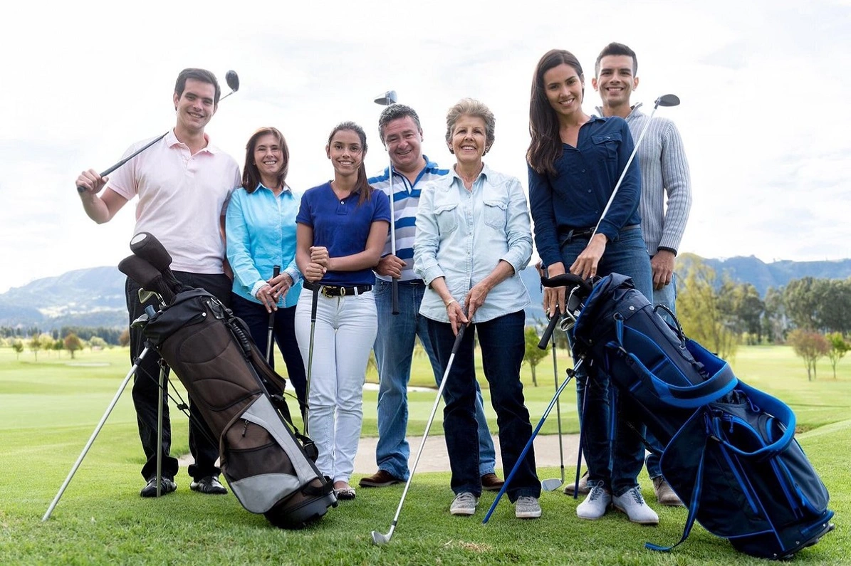 Large group of golfers standing together on the course, dressed in golf attire.