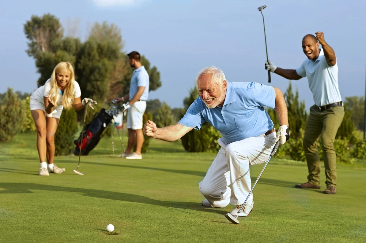 Elderly man playing golf on a sunny day, swinging a club on the green.